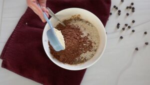 Adding dry ingredients to bowl for cookies